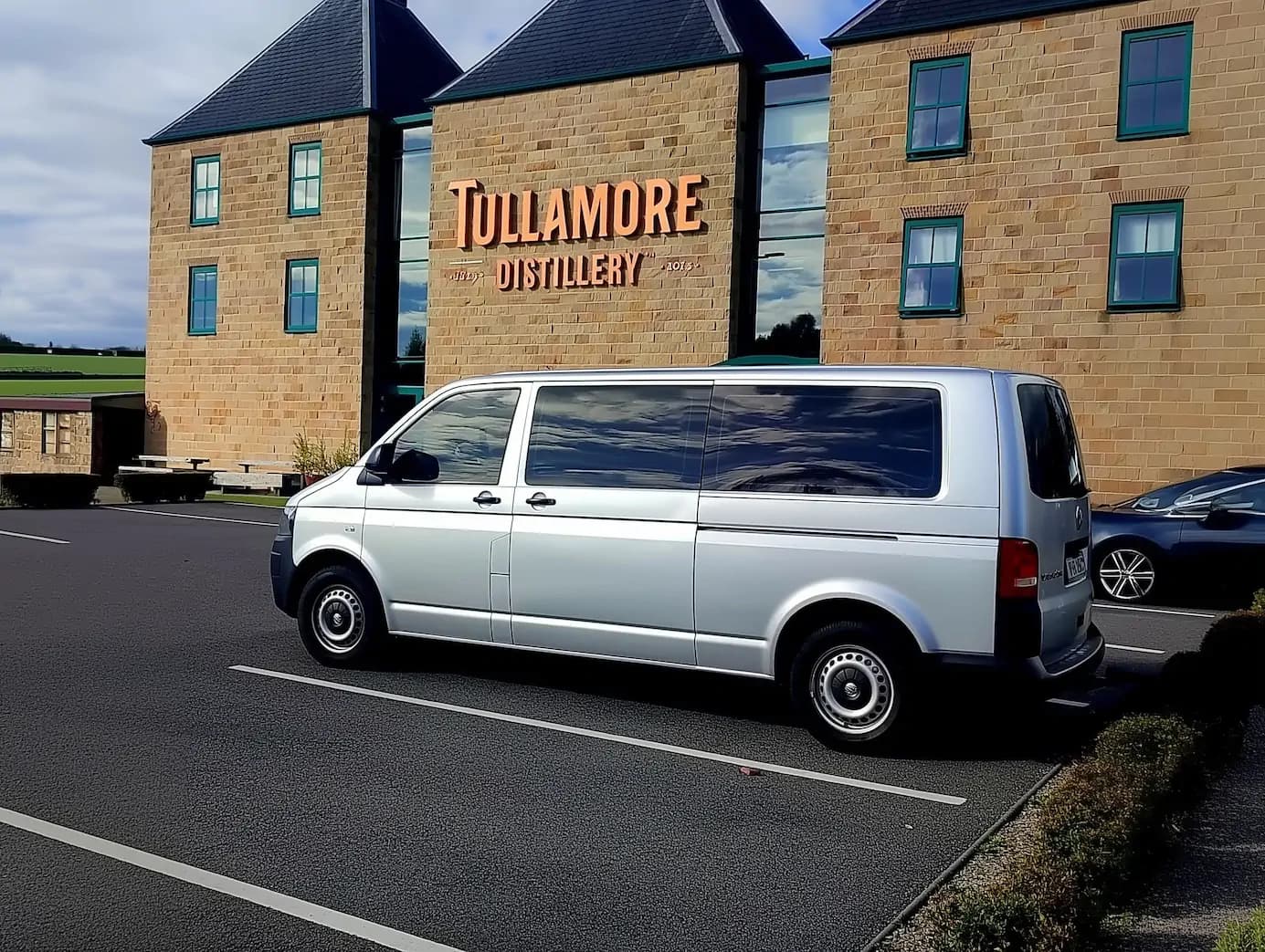 Sophisticated shuttle transfer arriving at Tullamore D.E.W. Distillery at twilight