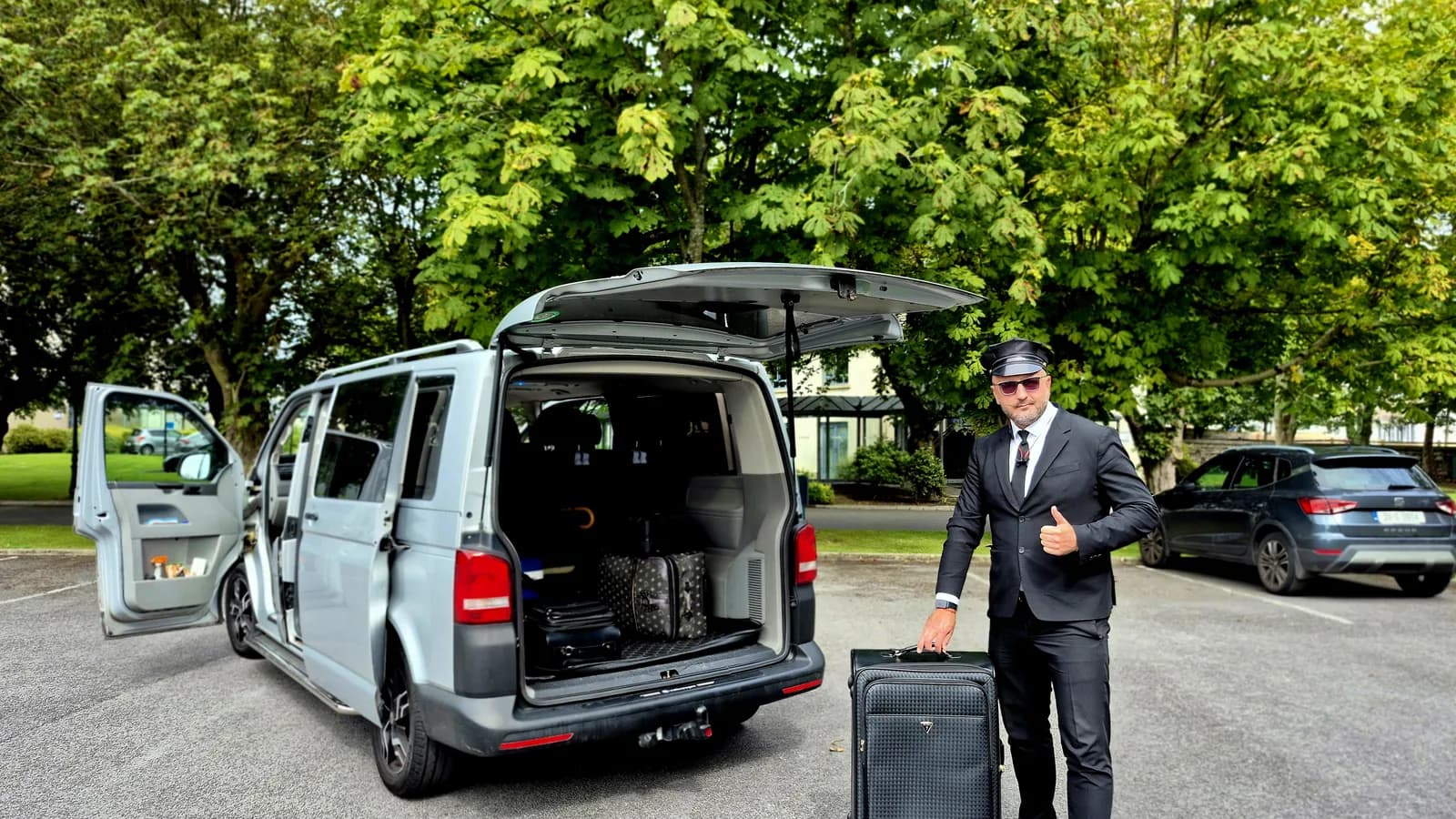 Chauffeur loading luggage into a private transfer vehicle before a long-distance journey from Dublin Airport