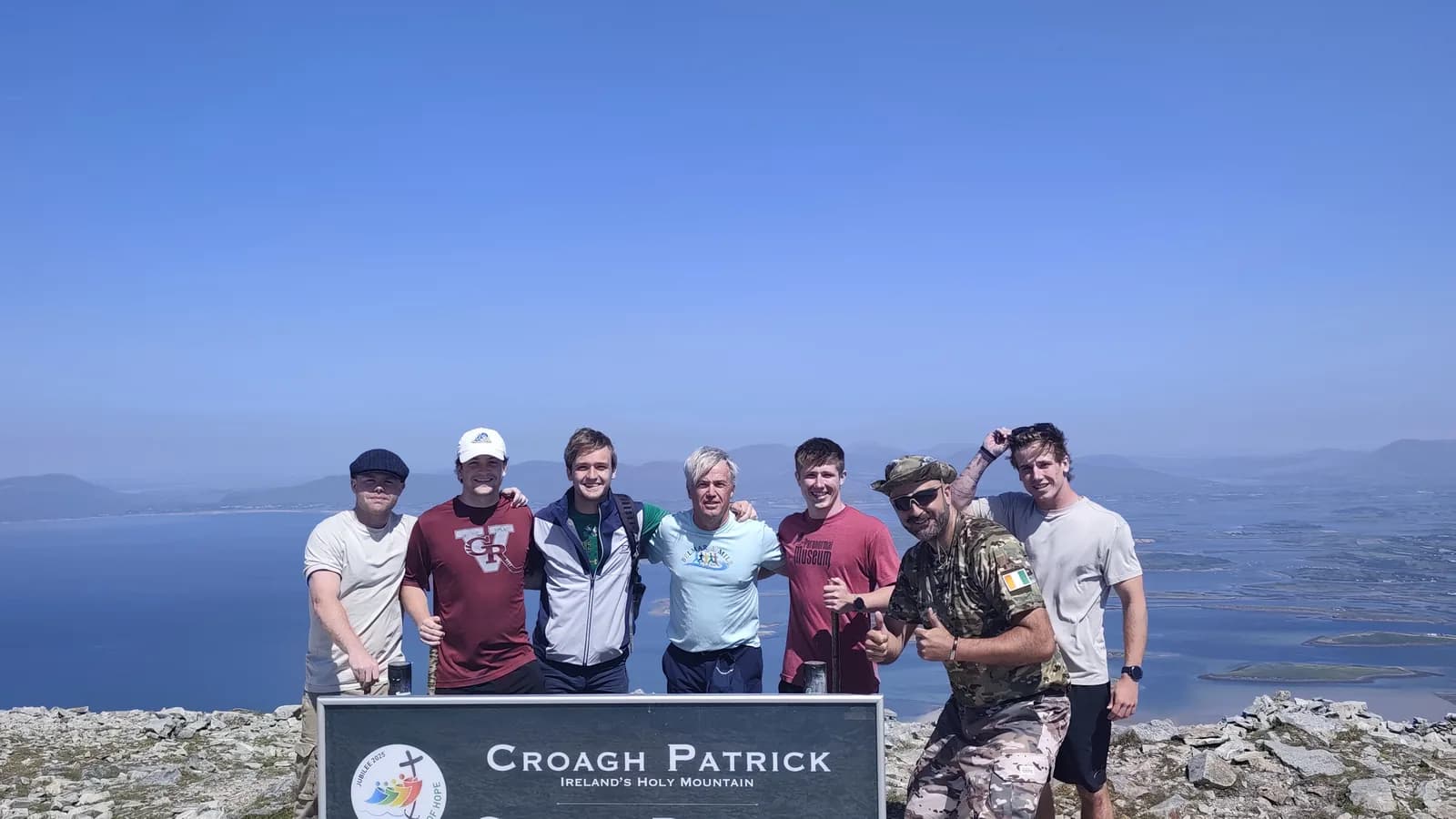 Walkers at the Croagh Patrick summit sign on a chauffeur-supported trekking day