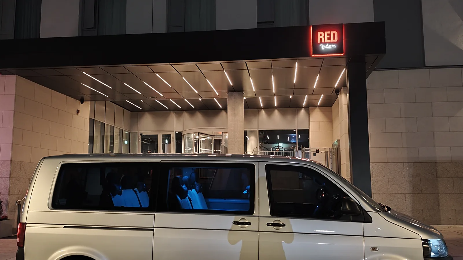 Executive private transfer van at a hotel entrance for an early pick-up