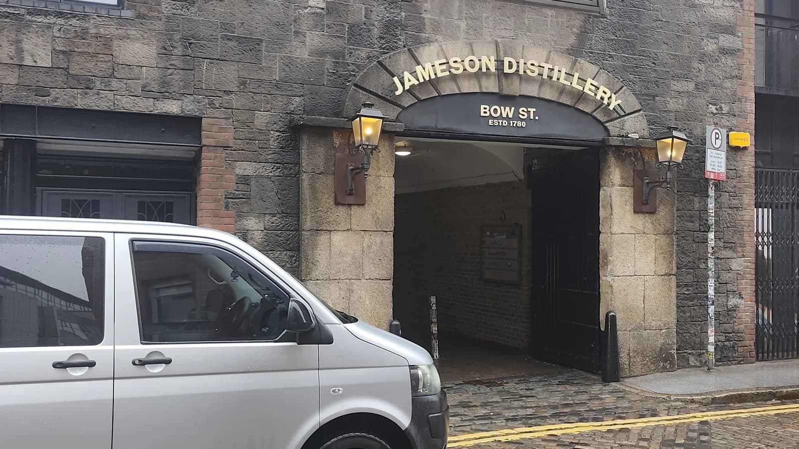 Silver Sophisticated Travels & Tours van parked on the cobbled street outside the arched Jameson Distillery Bow St entrance in Smithfield, Dublin