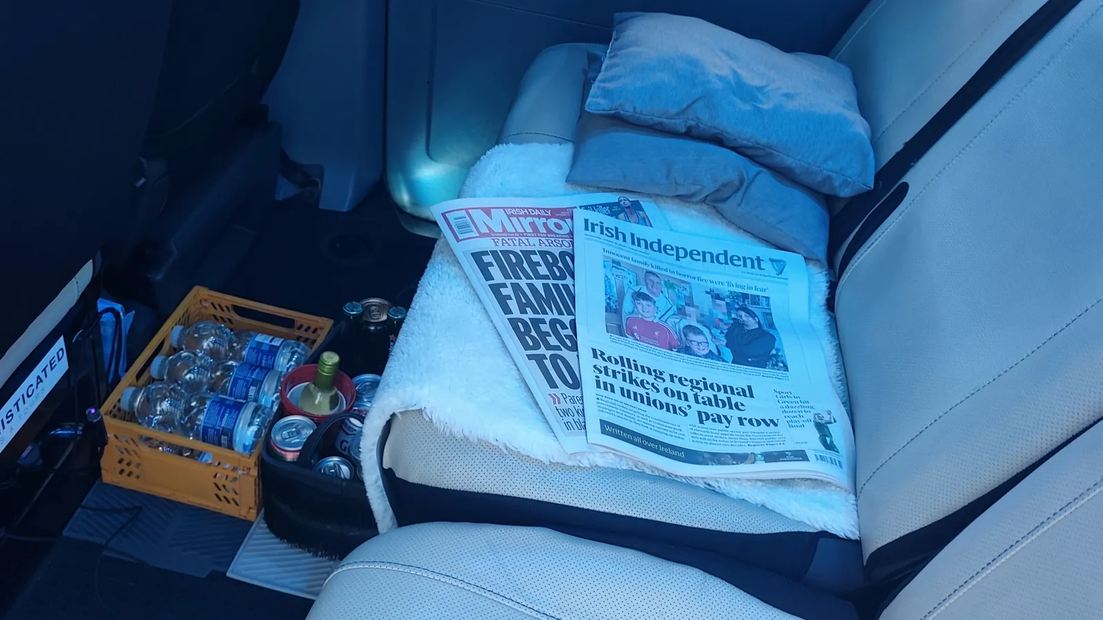 Rear bench with the day's newspapers, a soft cushion and a crate of chilled drinks for passengers