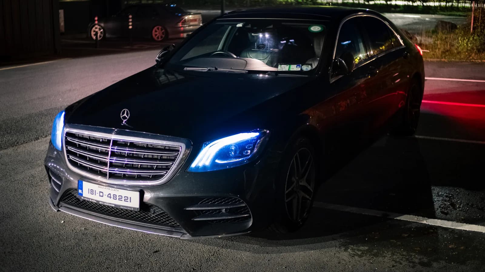 Black Mercedes-Benz S-Class at night with its LED headlights on