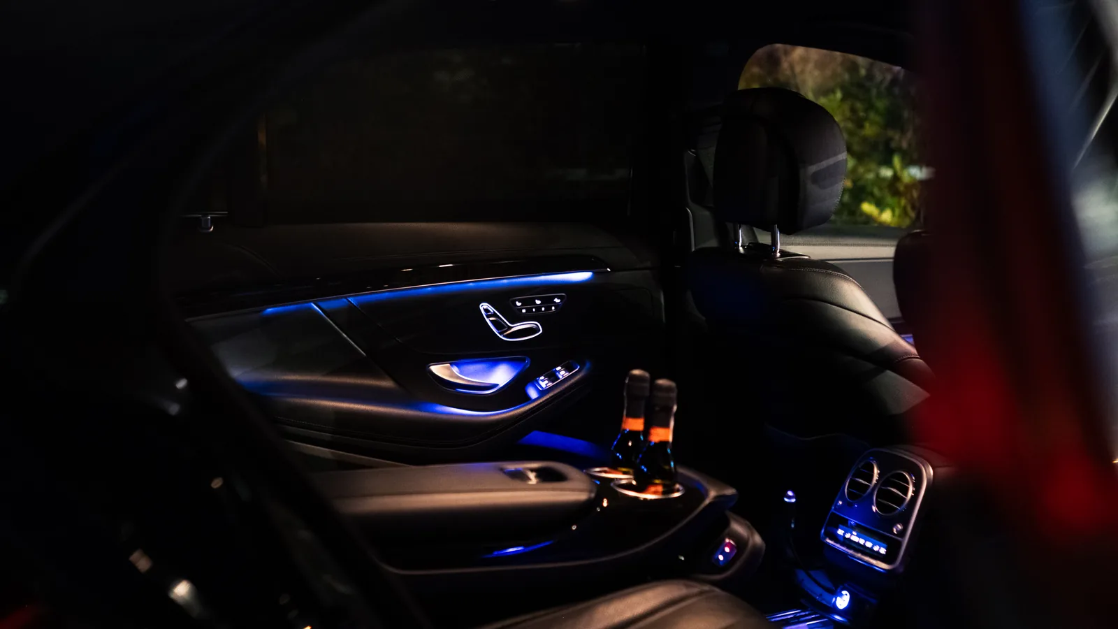 Rear seats and illuminated centre console of the Mercedes-Benz S-Class at night