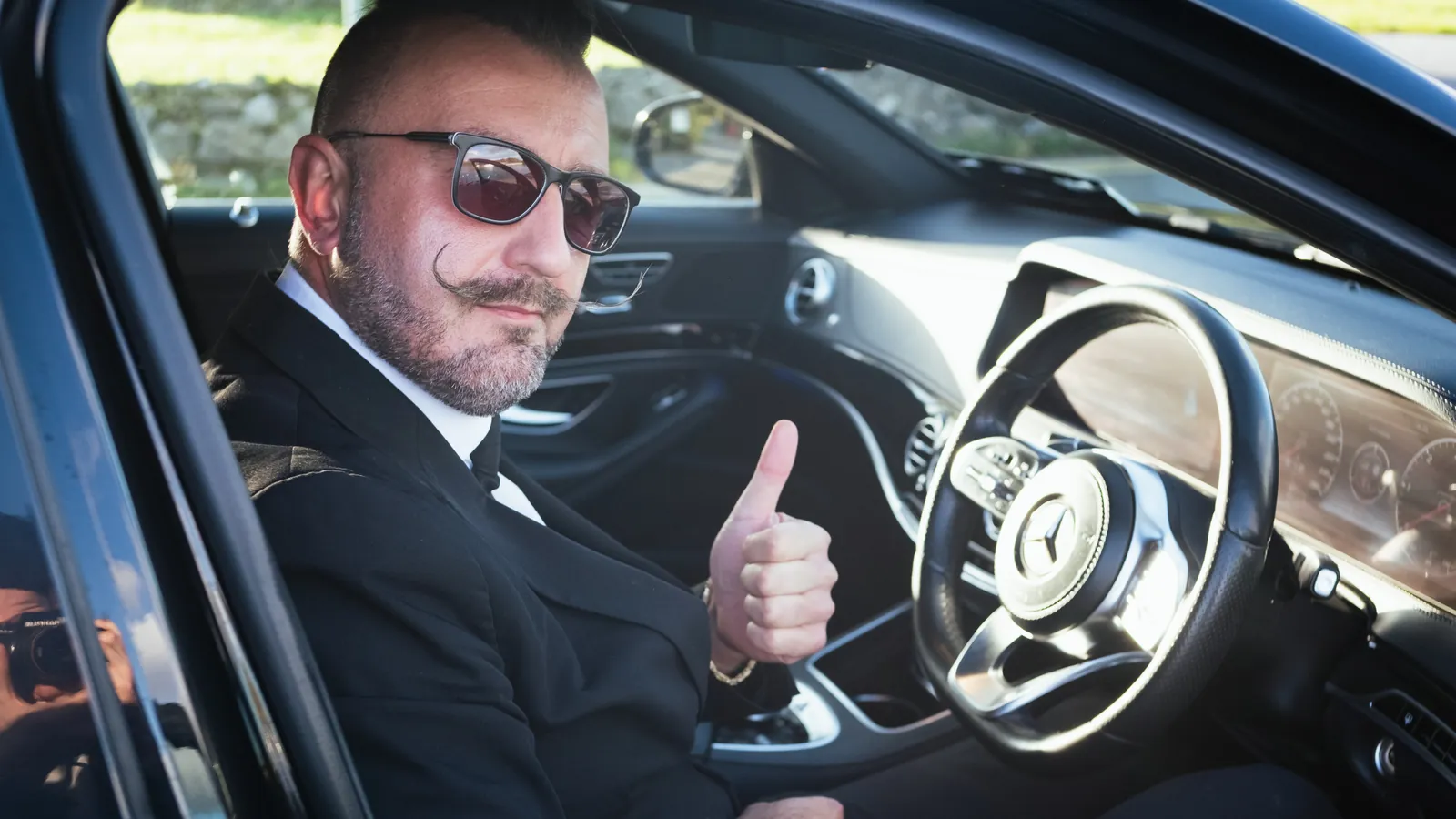 Sebastian giving a thumbs up from the driver's seat of the Mercedes-Benz S-Class