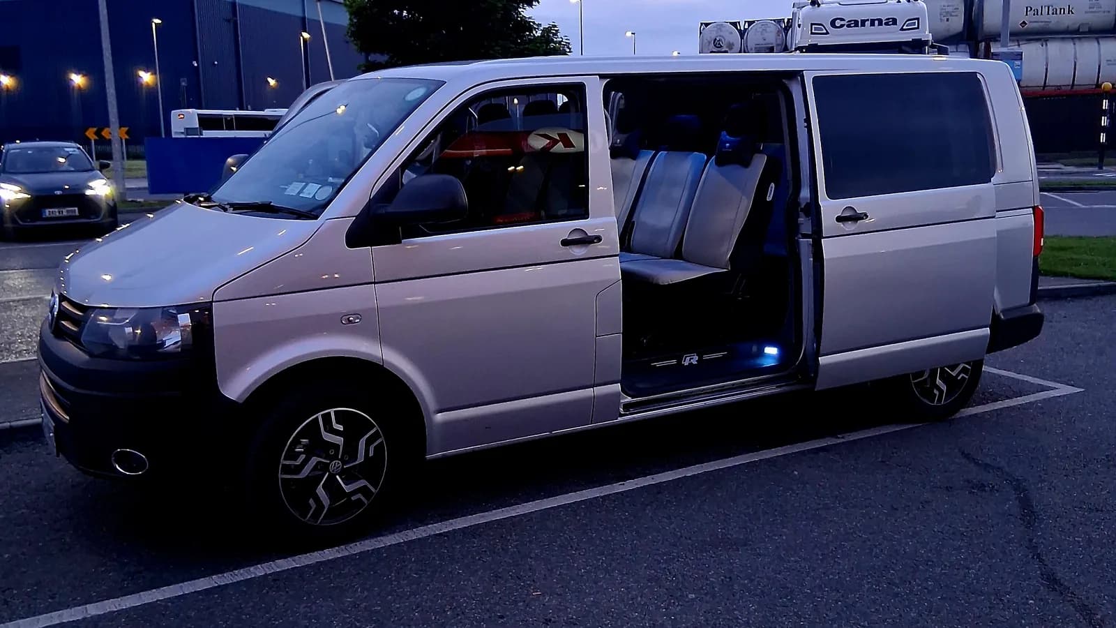 Executive van with sliding door open at an airport pick-up before a long-distance transfer