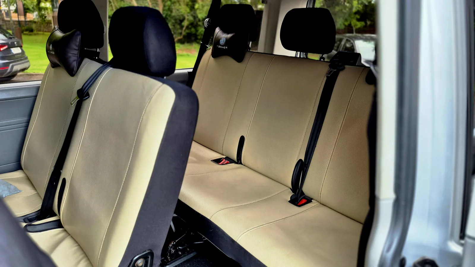 Cream leather seats and legroom inside the executive van used for airport transfers